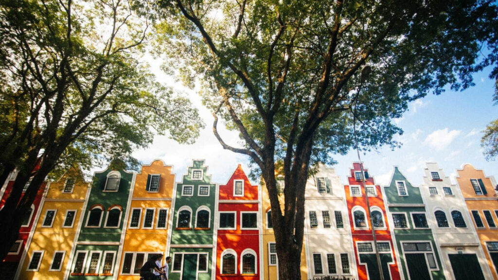 Fachada de prédios coloridos em estilo holandês e árvores