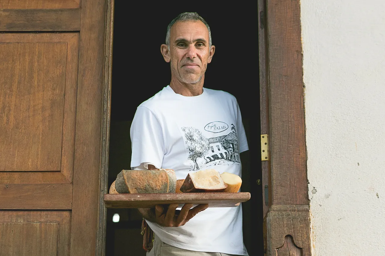Homem segurando bandeja de queijo