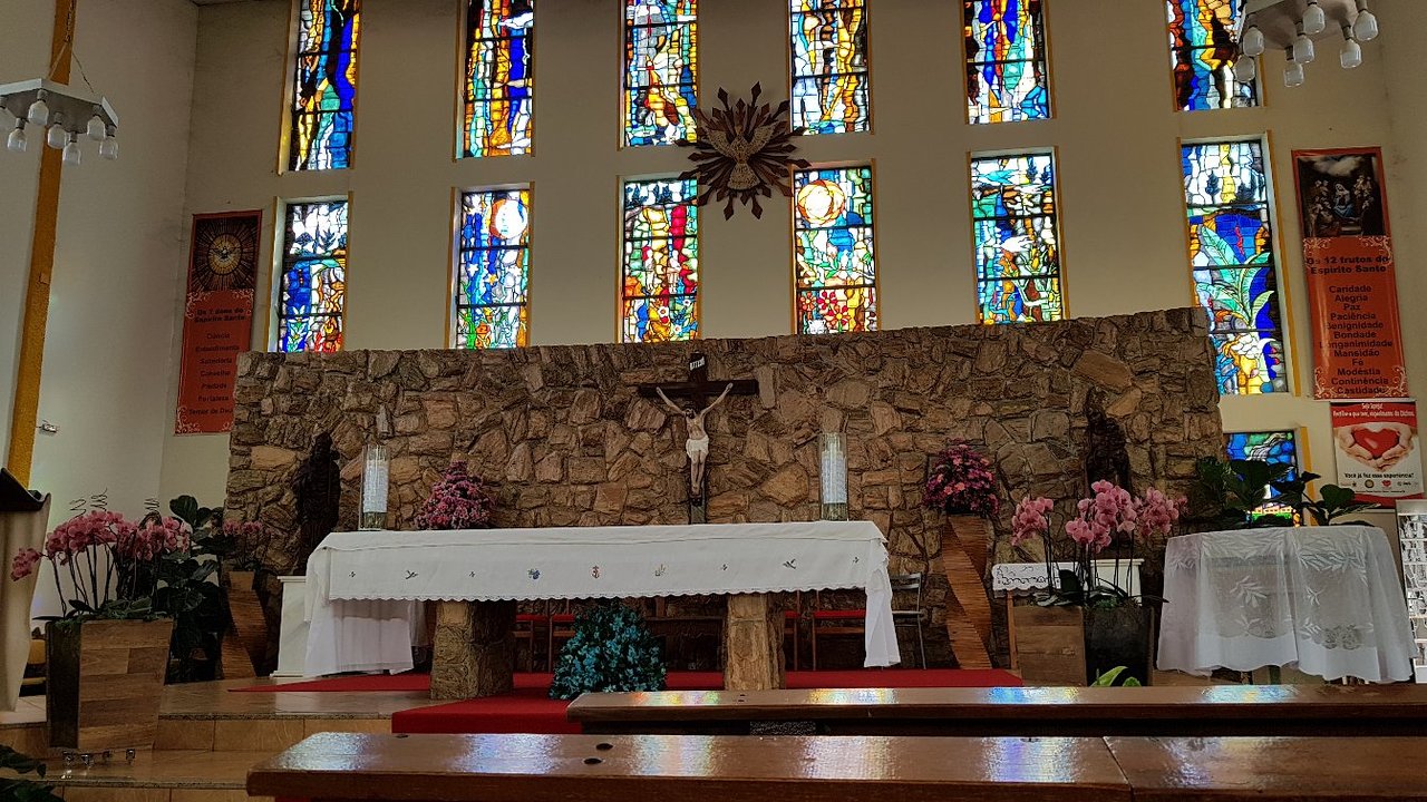 Altar de uma igreja católica com vitral colorido